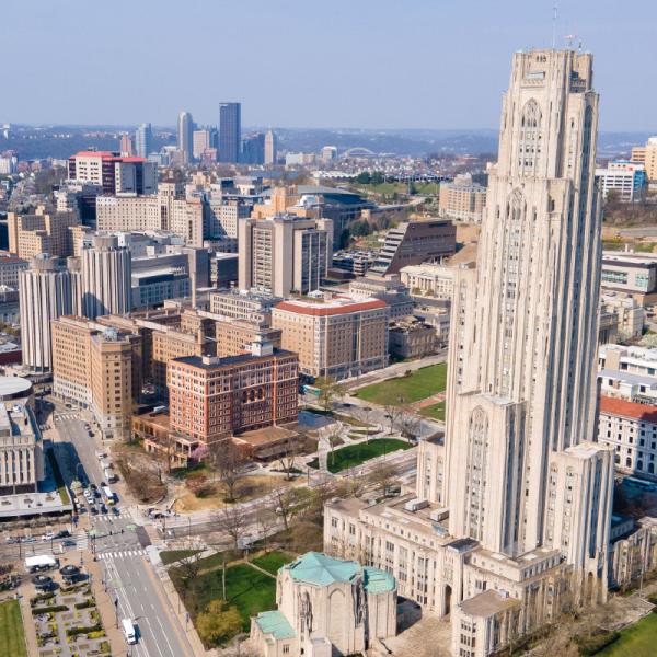 a drone image of oakland with the cathedral of learning in the foreground